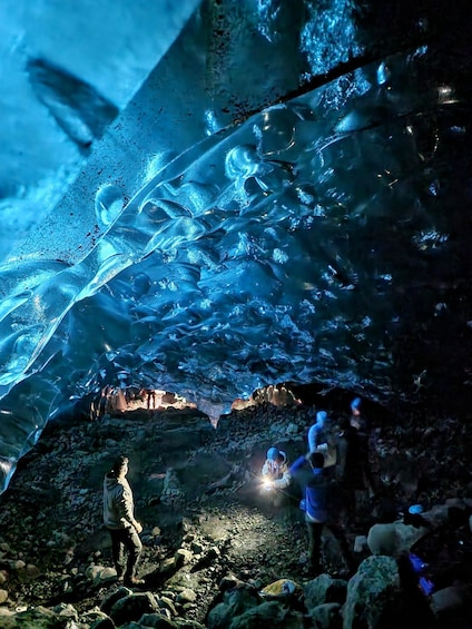 A person taking a photo of an ice cave with a flashlight. 5