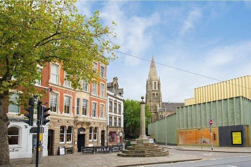 A street with historic buildings, a church tower, and a modern building. 5