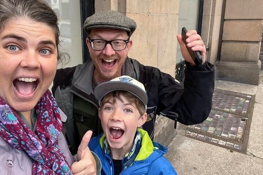 Three people in front of a building with a stone facade and a metal door. 4