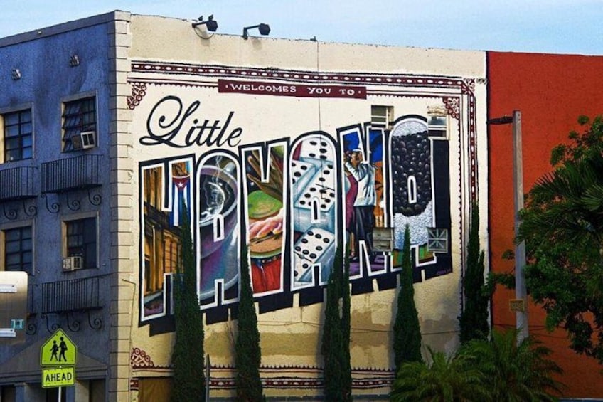 A mural on a building with the text 'Little Hong Kong' and a welcome sign. 4