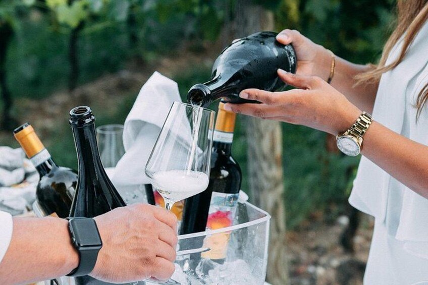 A person pouring wine into a glass from a bottle. 2
