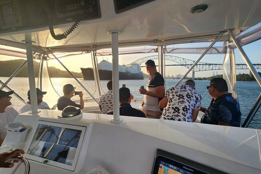 A boat with people on deck, a bridge in the background, and a body of water. 5