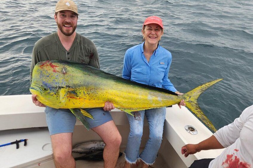 Two people holding a large fish on a boat. 4