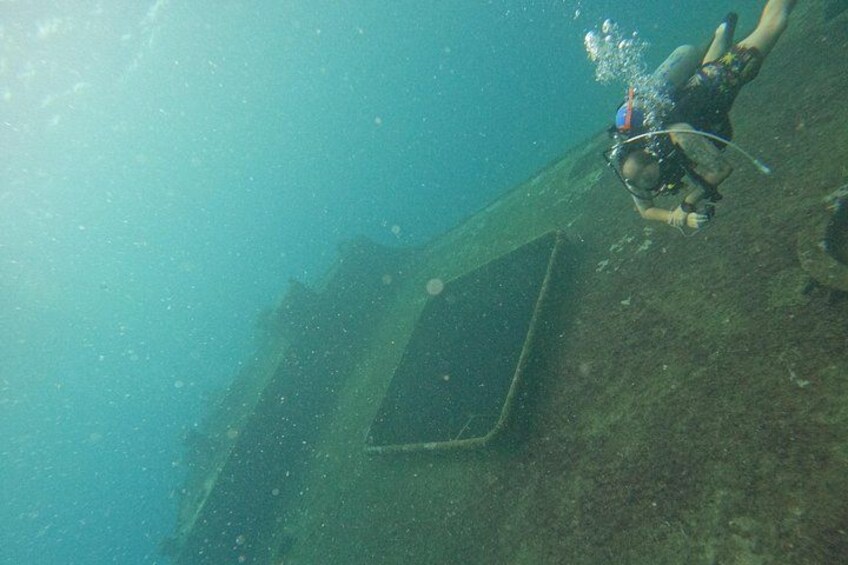 Een duiker onder water, een ondergelopen structuur en luchtbelletjes. 3