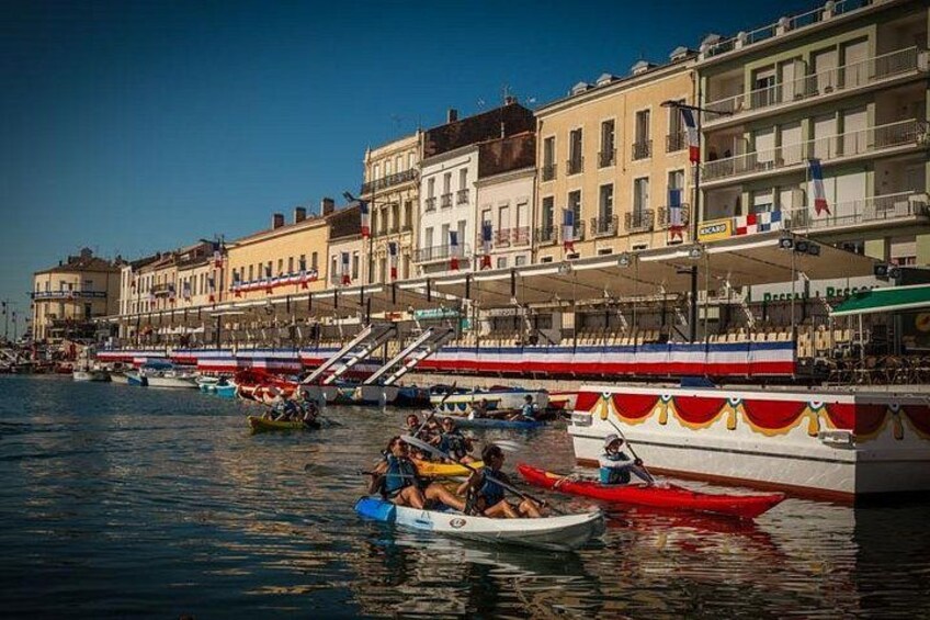 A waterfront with boats, buildings, and a clear sky. 1