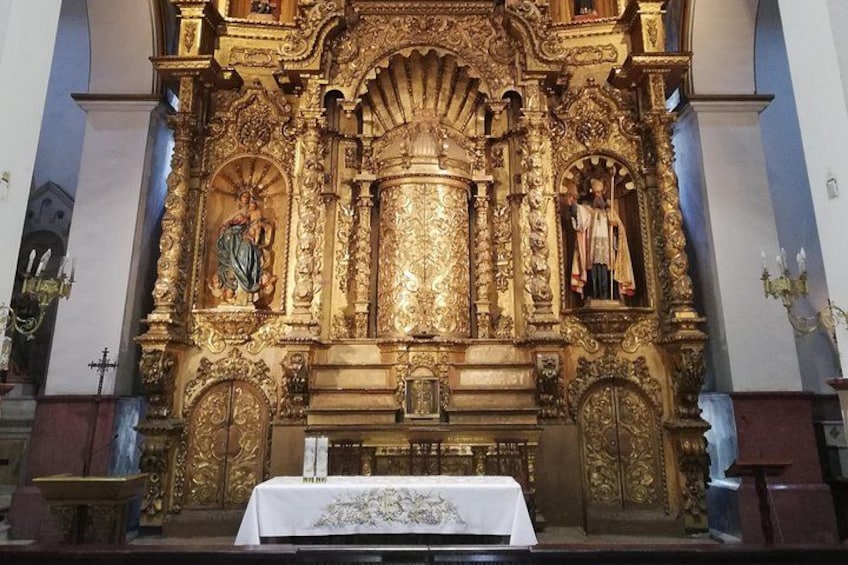 An ornate religious altar with intricate gold detailing and statues. 1