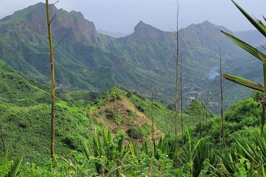 A mountainous landscape with lush greenery and a small village in the valley. 4