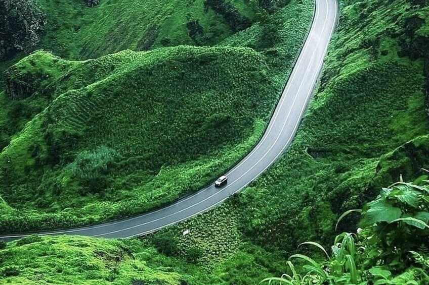 A winding road through lush green hills. 5