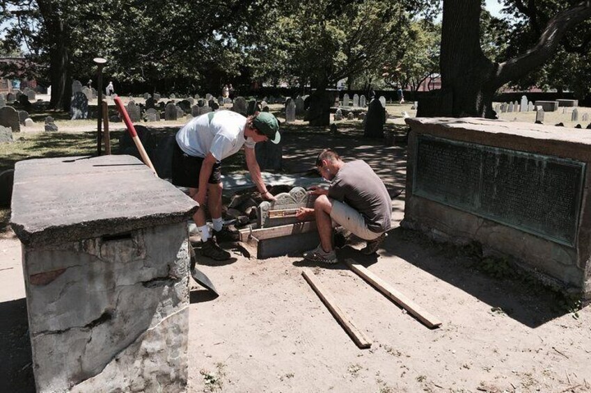 Due uomini lavorano a una struttura in cemento in un cimitero. 5