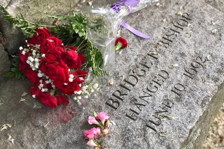 A gravestone with inscriptions and a bouquet of flowers. 2