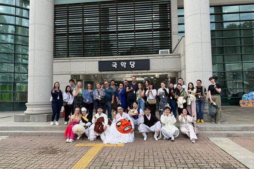 A group of people posing in front of a building with a sign that reads '국악당'. 3