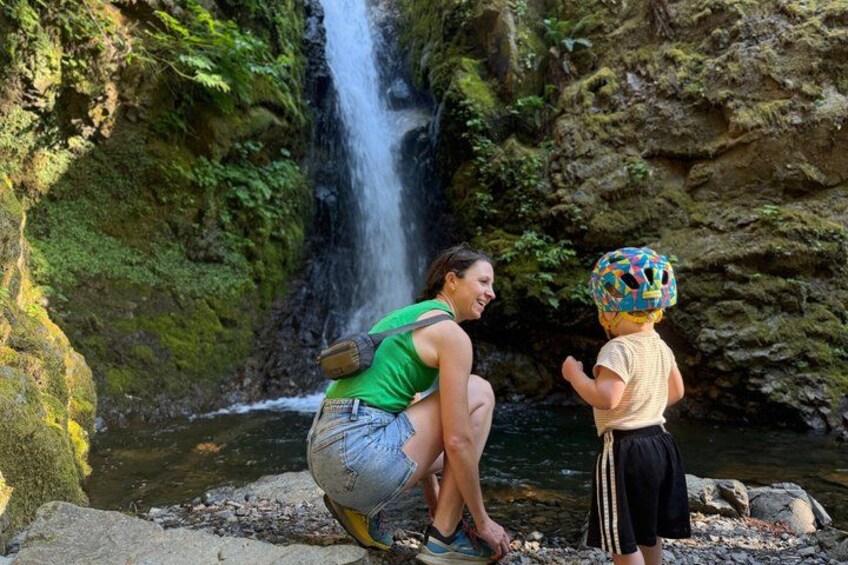 A waterfall, rocky terrain, and a person crouching near a stream. 5