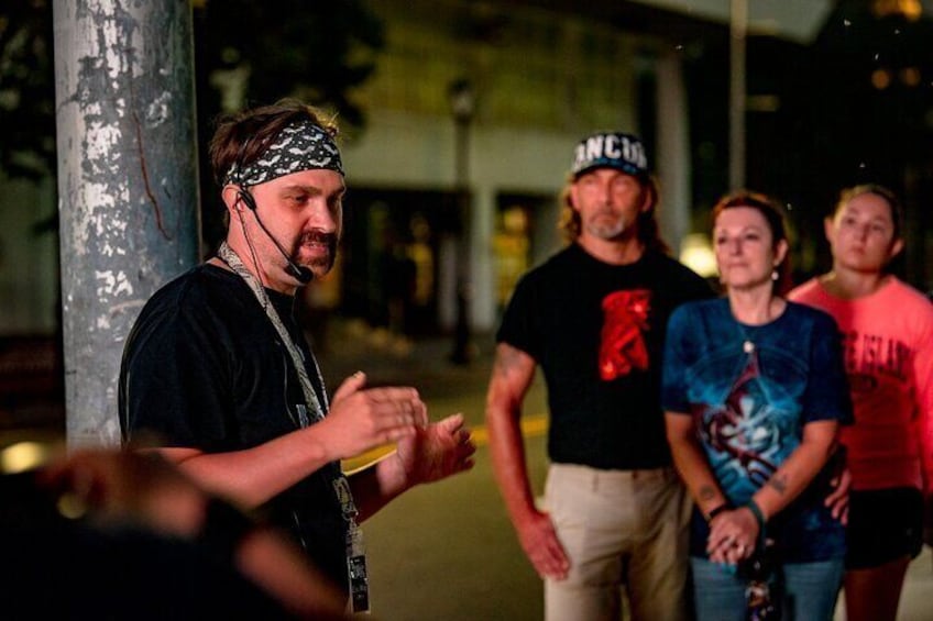 A group of people standing outdoors at night. 4