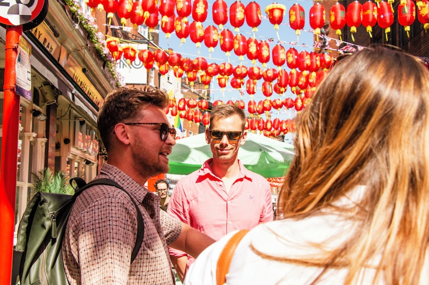 A street with red lanterns, a man in a pink shirt, and a woman with blonde hair. 3