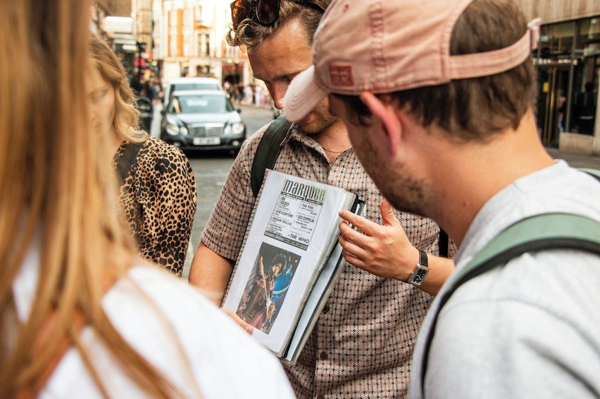 A group of people on a city street, one holding a magazine. 4