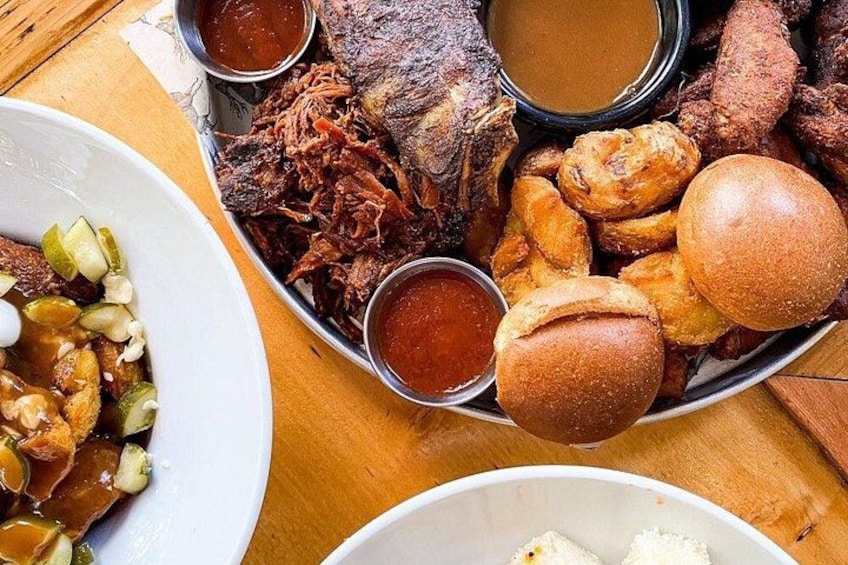 A variety of fried foods including fried fish, chicken, and sausages, served with dipping sauces and bread rolls. 2