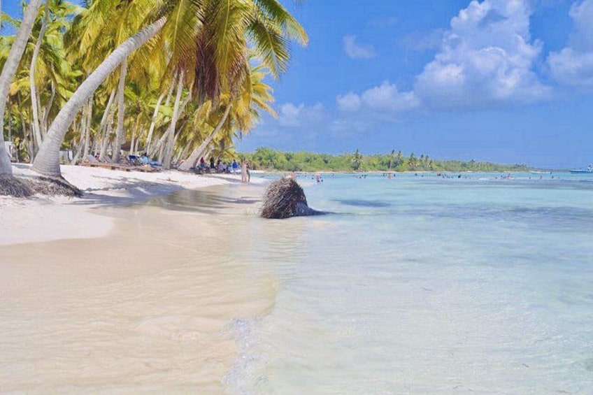 A beach with clear turquoise water, white sand, and palm trees. 4