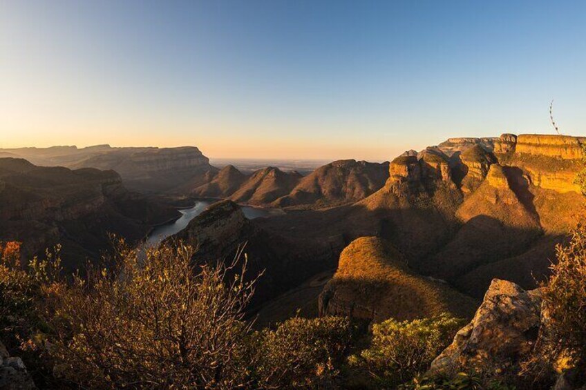 A canyon landscape with layered rock formations and a river. 4