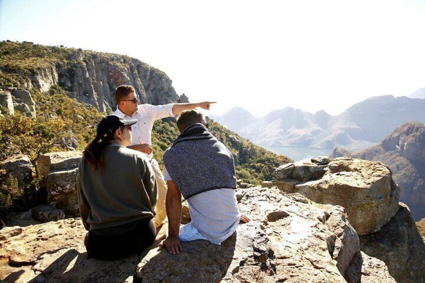 A group of people on a rocky outcrop overlooking a mountainous landscape. 3
