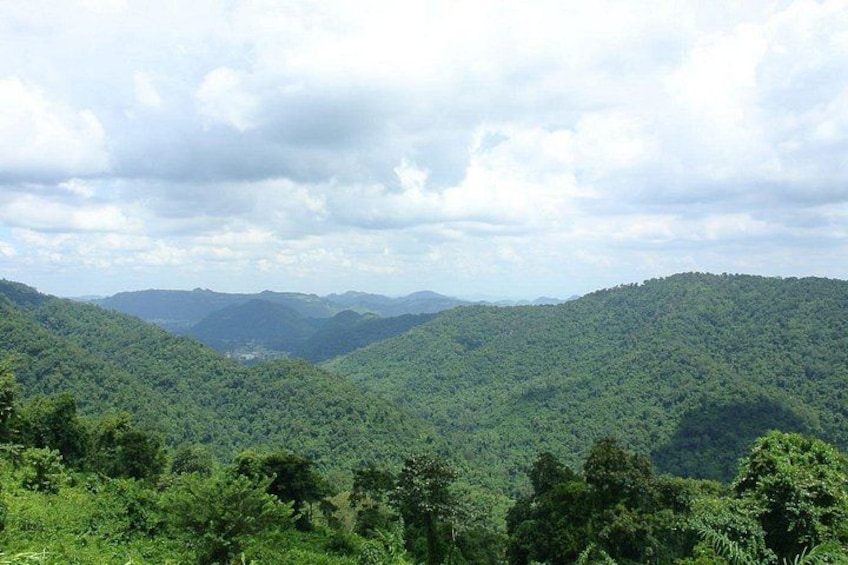 A mountainous landscape with dense green forests and a valley. 3