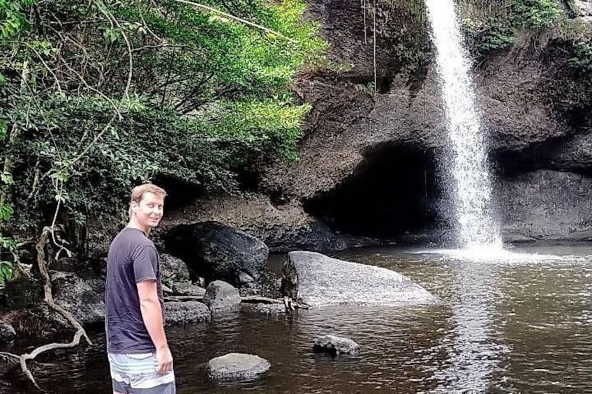 A waterfall, rocks, and a person standing by the water. 2