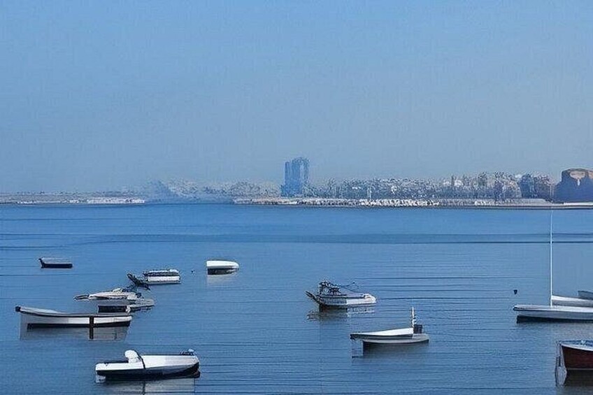 A calm body of water with several small boats anchored. 2