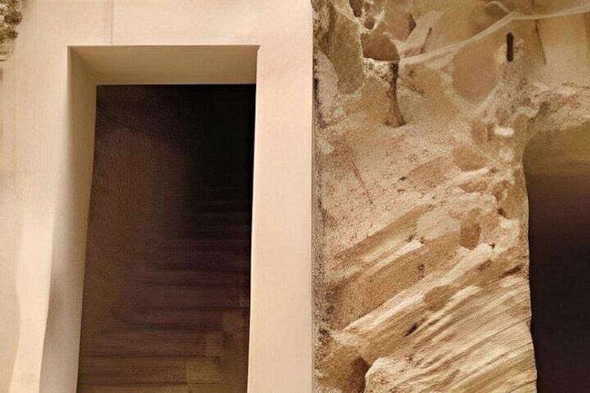 A doorway with a textured wall and a rough, stone-like surface to the right. 3