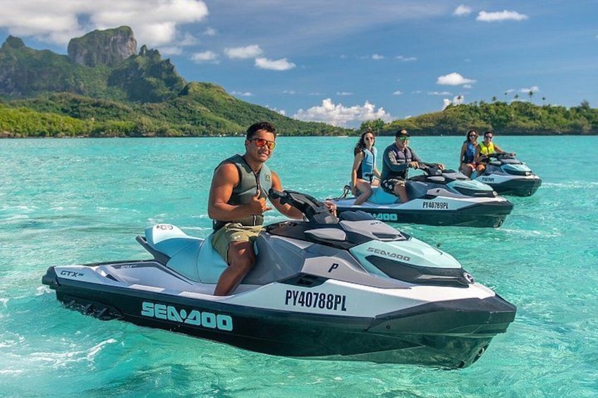 Jetski's op turquoise water, met een bergachtig landschap op de achtergrond. 1
