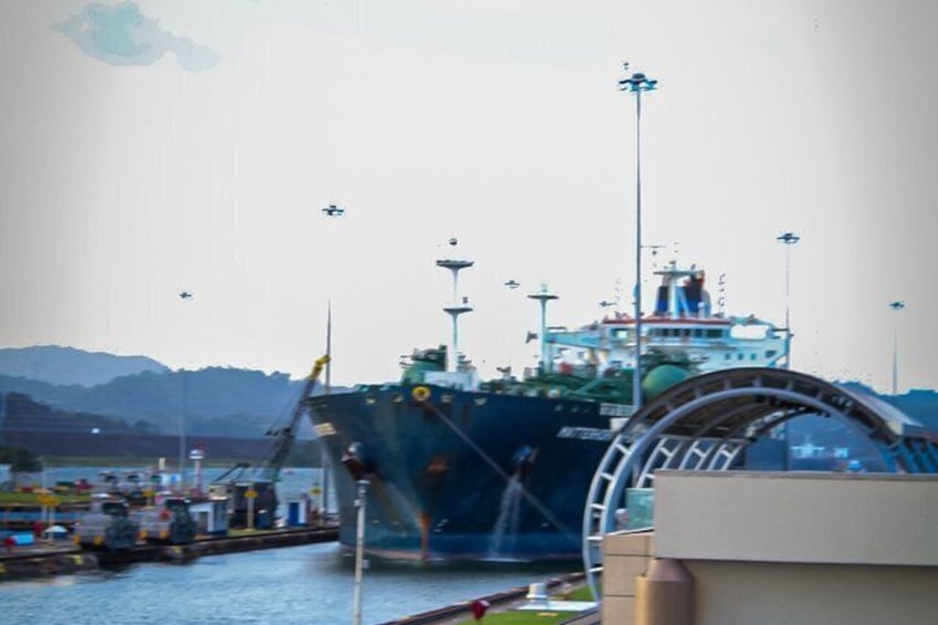 Una grande nave ormeggiata in un porto, con montagne sullo sfondo. 4