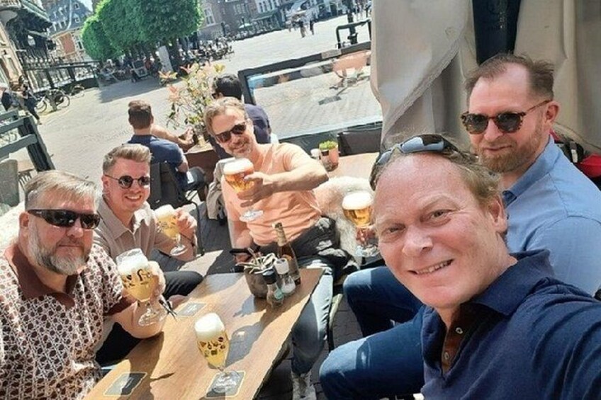 A group of people sitting at an outdoor table, enjoying drinks and food. 2