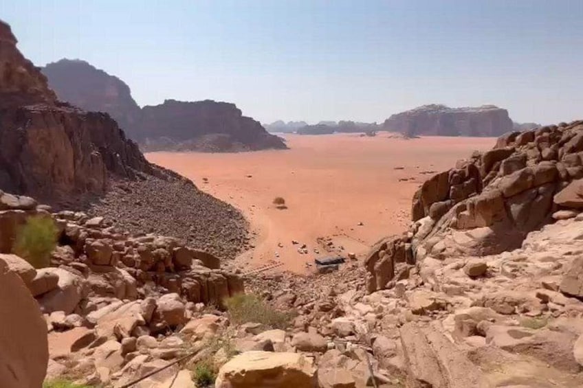 A desert landscape with rocky terrain and a vast sandy area. 3