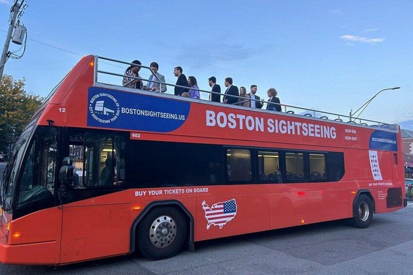 Een rode dubbeldekkerbus met 'BOSTONSIGHTSEEING' en 'BOSTON SIGHTSEEING' erop geschreven. 2