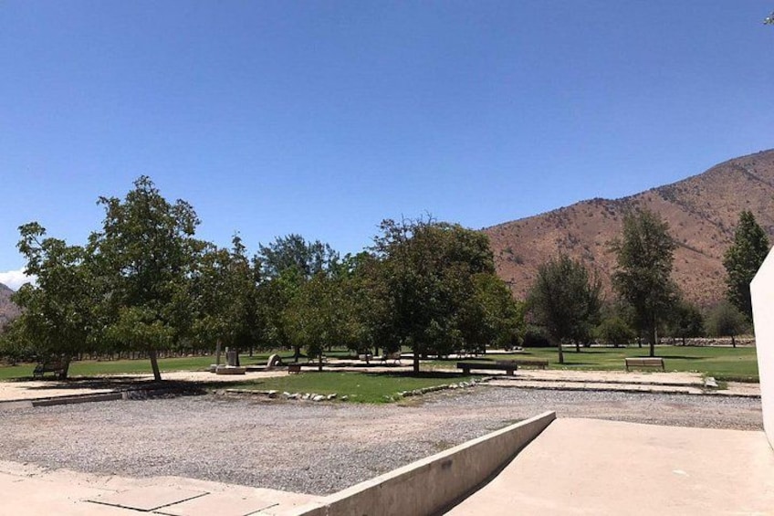Un parque con árboles, bancos y una montaña al fondo. 2