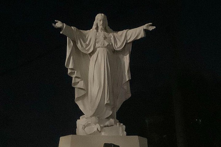 A statue with outstretched arms, draped clothing, and a base with a floral design. 3
