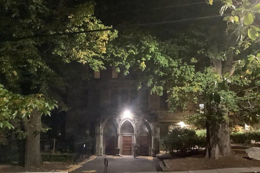 A building with arched entrances, surrounded by trees and illuminated by artificial light. 2