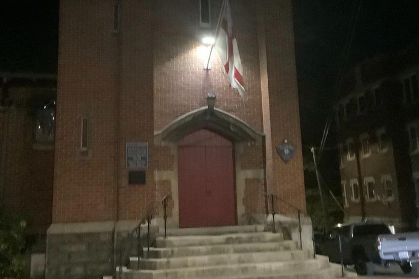 A brick building with a red door and steps leading up to it. 5