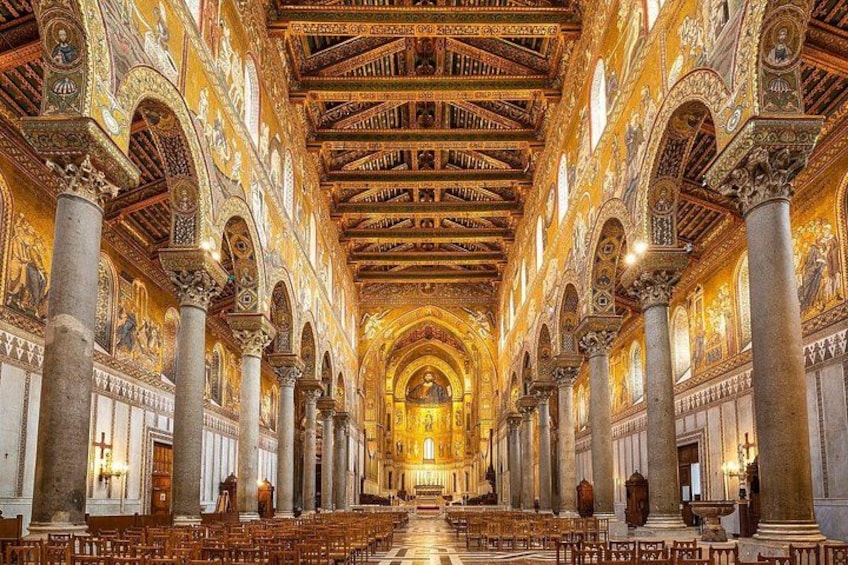 Interior de una iglesia ornamentada con techos altos, frescos detallados y hileras de bancas. 5