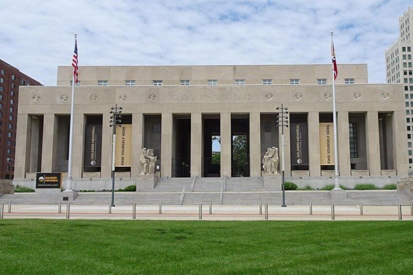 A large building with a grand entrance, columns, and steps leading up to it. 2