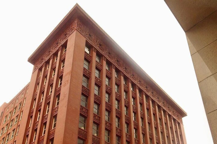 Un grand bâtiment en briques rouges, doté de détails architecturaux complexes et de nombreuses fenêtres. 2