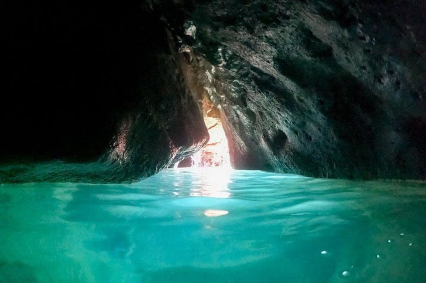 Eine Höhle mit einem Wasserbecken und einer Lichtquelle am Ende. 4
