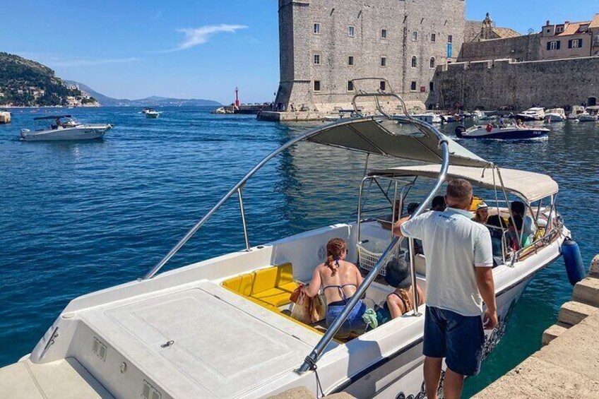 A boat docked at a harbor with a historic building in the background. 4