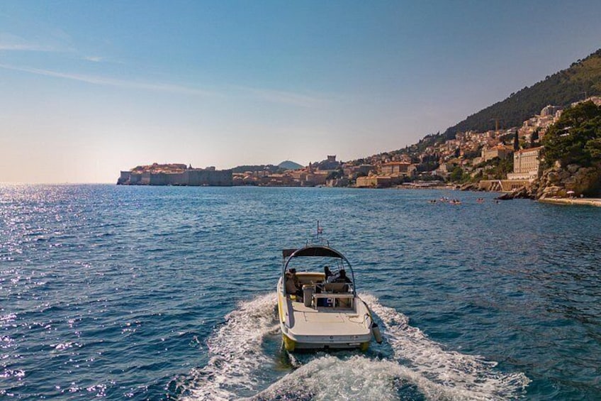 A boat moving through a coastal area with buildings on the shore. 2