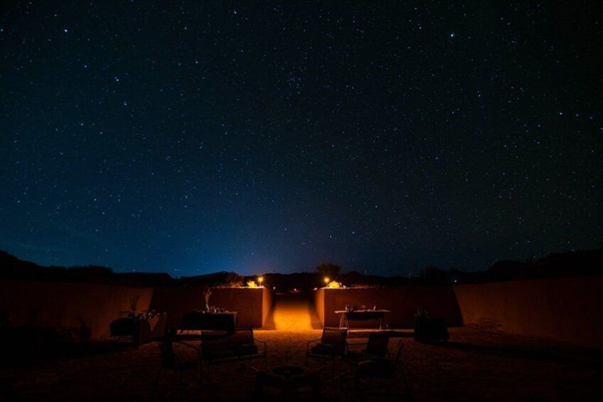 Un ciel étoilé au-dessus d’un paysage désertique, avec des structures illuminées. 4