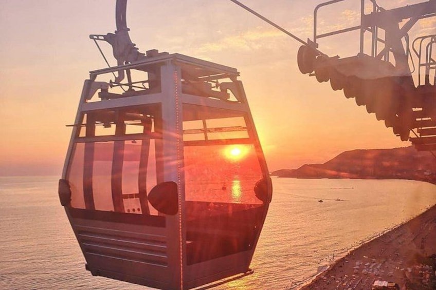 A cable car at sunset with the sun setting on the horizon. 1