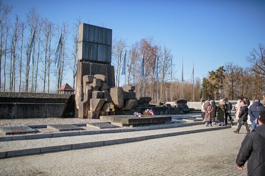 A memorial with a large stone structure and steps, surrounded by bare trees and a clear sky. 3