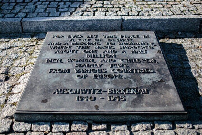 A memorial plaque on a cobblestone surface. 2