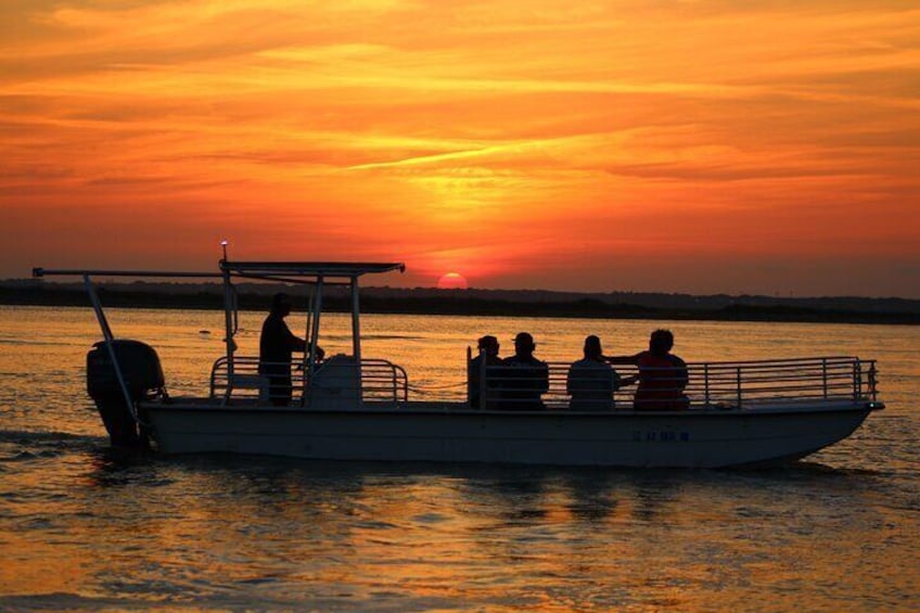 A boat with people on it during sunset. 3
