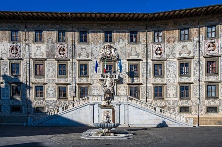 A building with ornate facade and a statue on a pedestal. 2
