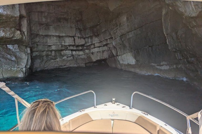 A boat in a cave with clear water. 2