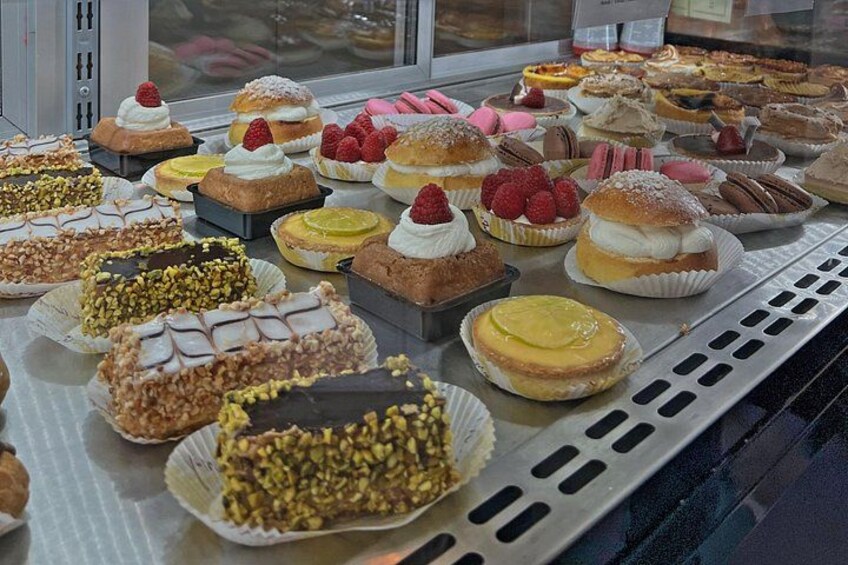 A variety of pastries and desserts displayed in a bakery. 2
